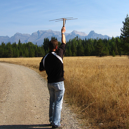A researcher holds up an antenna.