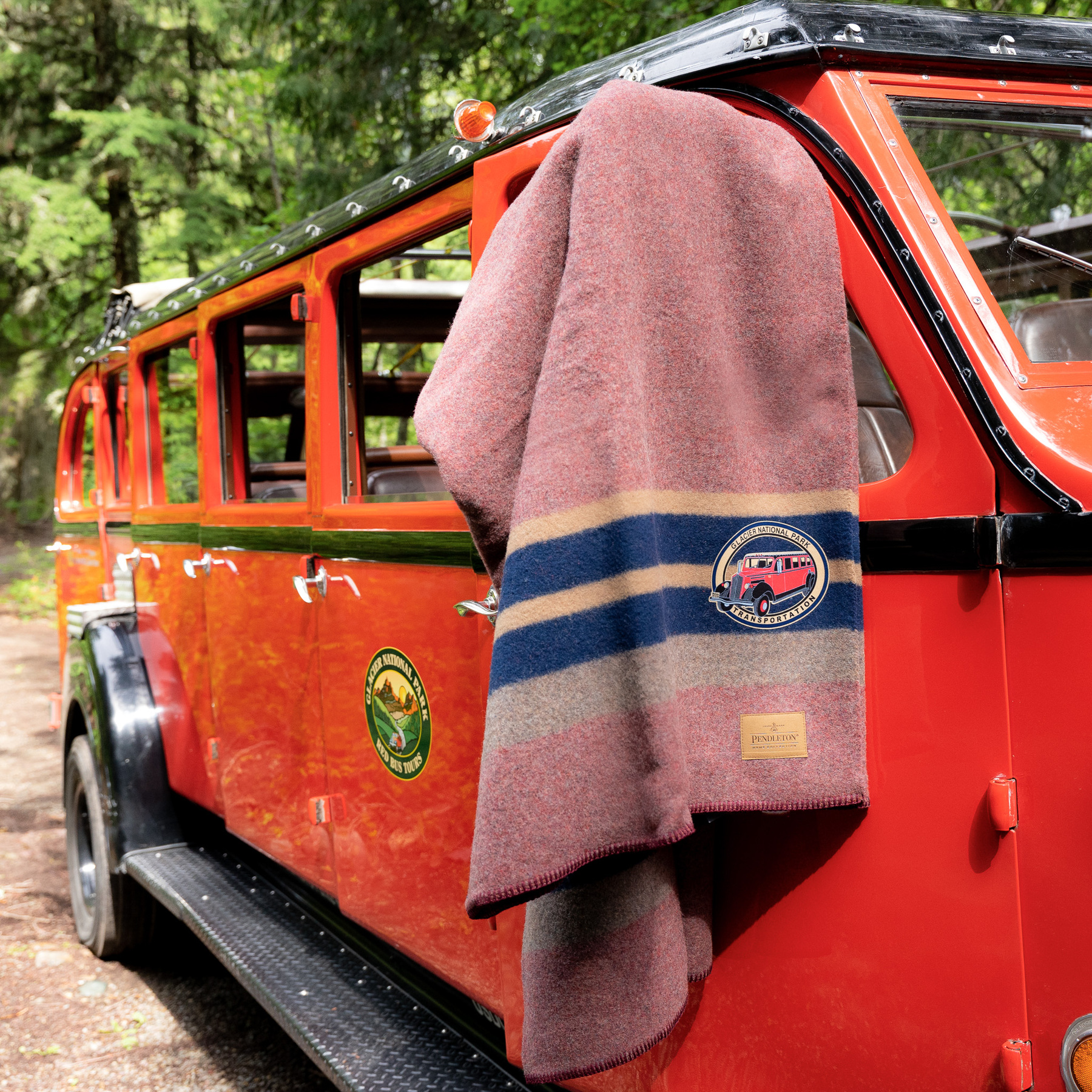 red bus pendleton blanket draped over the side mirror of a red bus