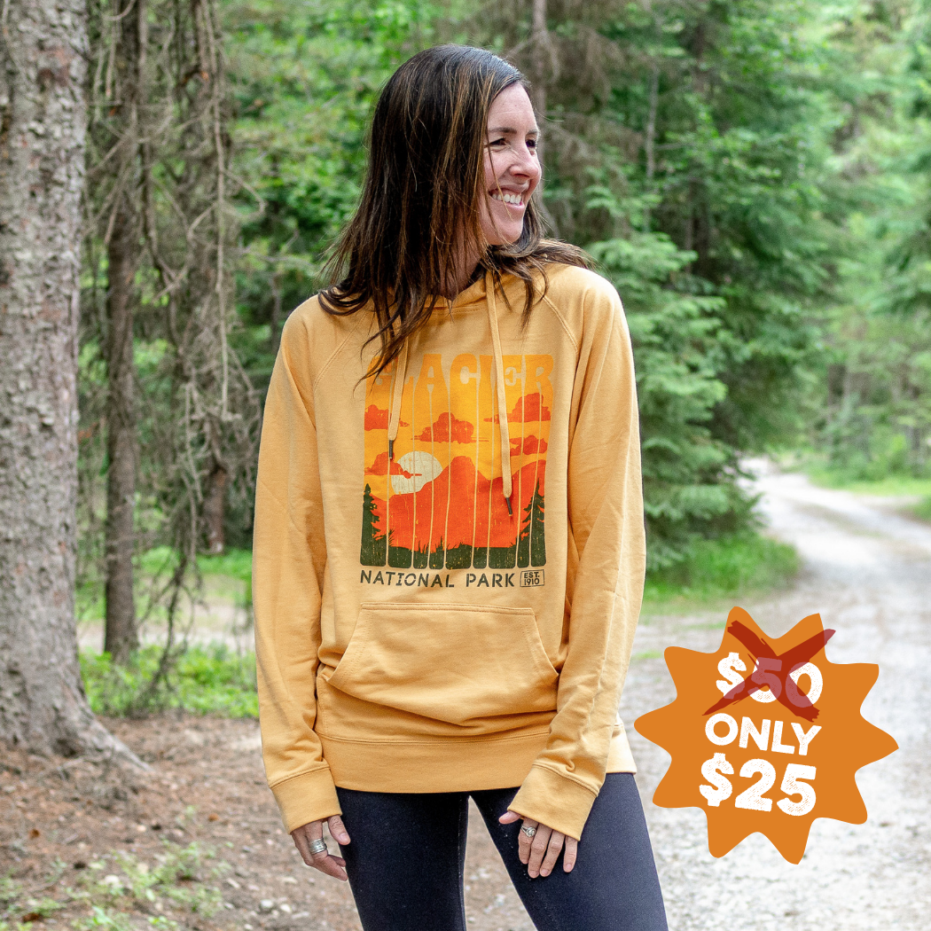 a woman wearing a yellow hoodie in the woods