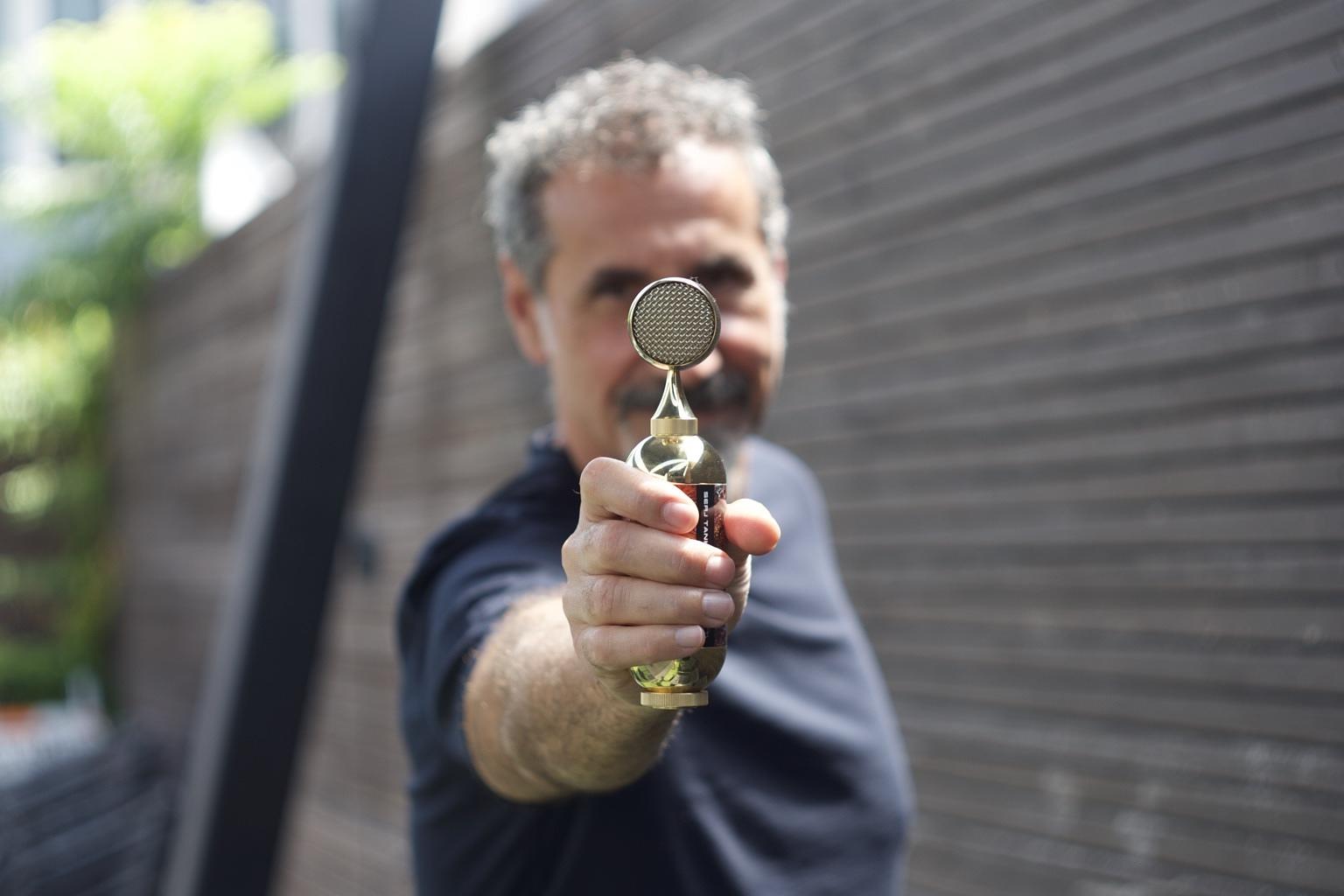 Serj Tankian holding out his Wax Brass 023 Bomblet microphone