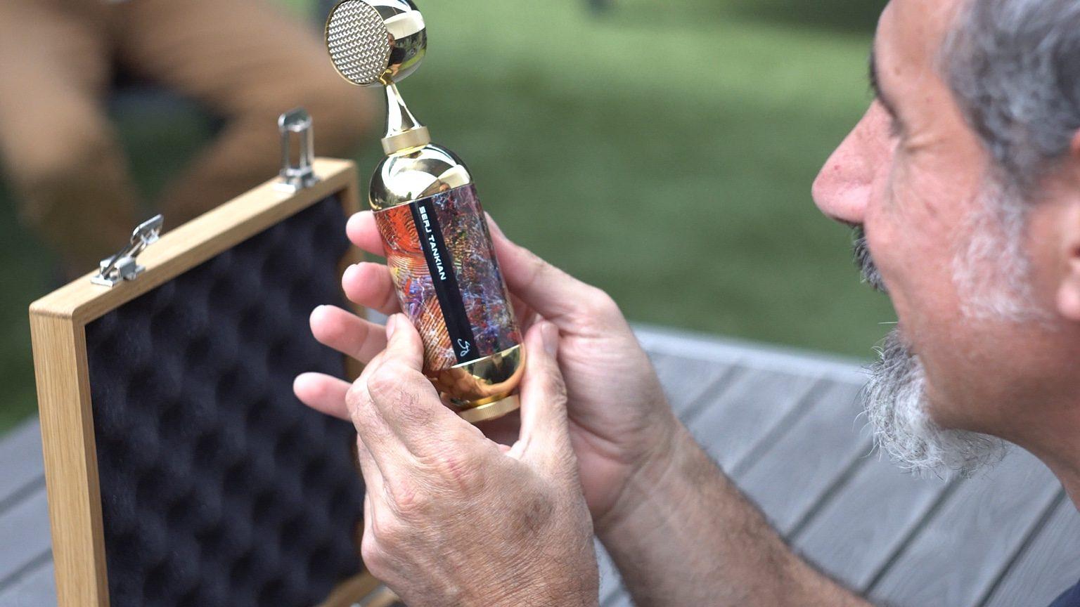 Serj examining the microphone’s artwork beside its open oak case