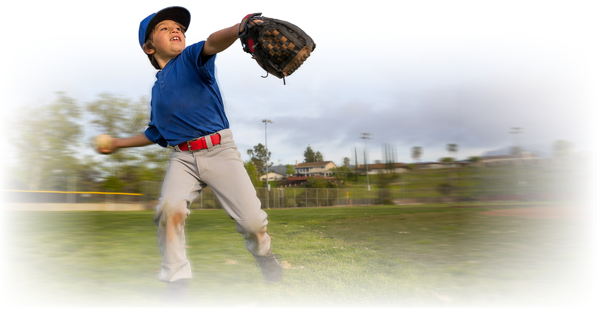 Youth baseball pitcher mid-throw
